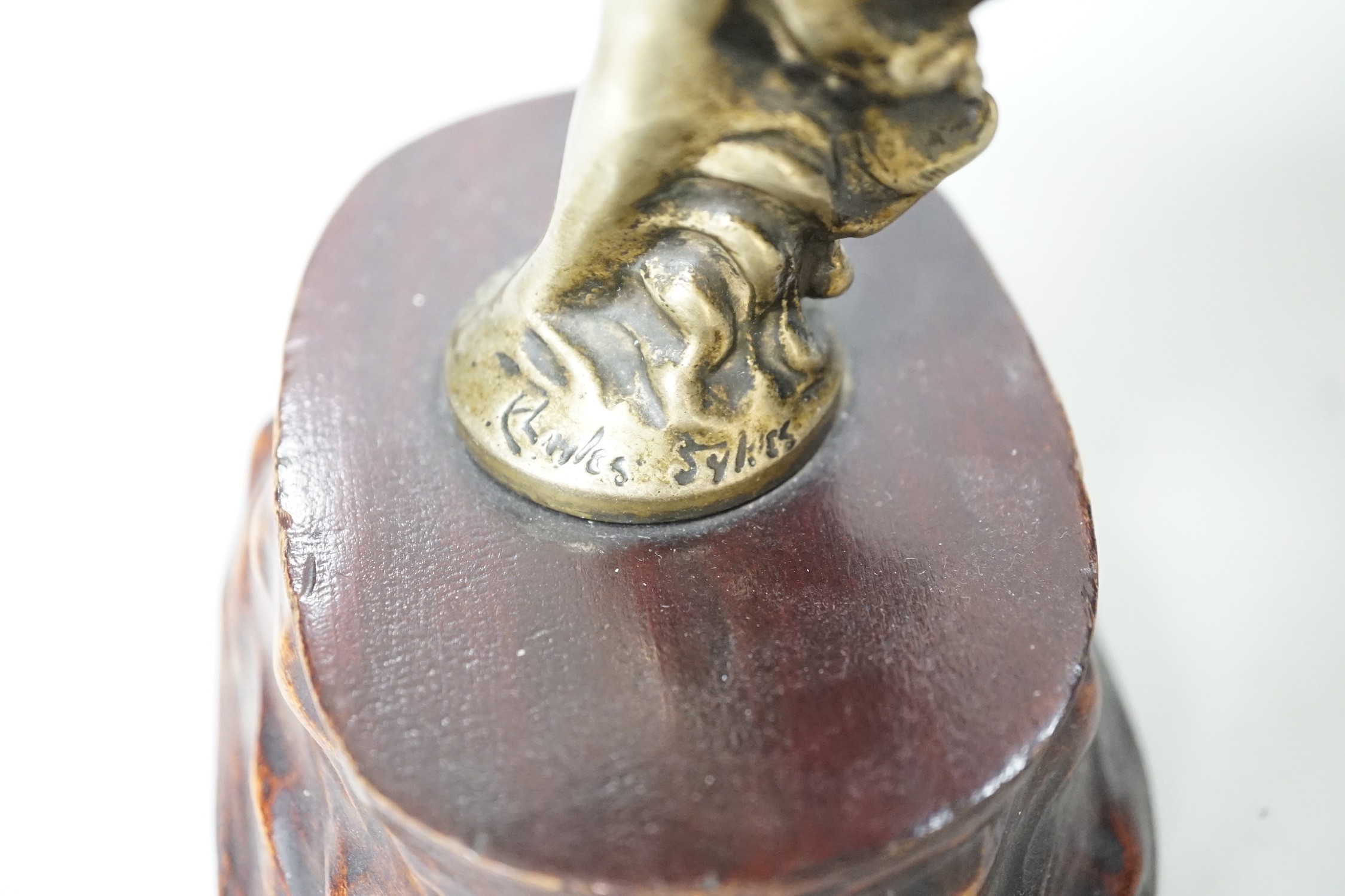 After Charles Sykes, a gilt metal Rolls Royce car mascot - ‘’Spirit of Ecstasy’’, inscribed and bearing date 1911, on a carved wooden plinth. 17.5cm tall